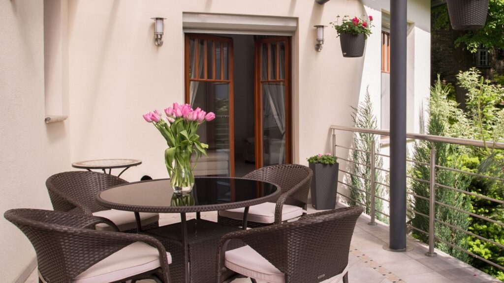RATTAN DINING TABLE AND CHAIRS ON COVERED BALCONY